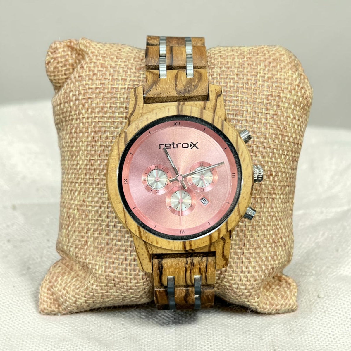 Retro X zebra wood chronograph watch with rose pink dial, three subdials and date window, shown on a burlap pillow